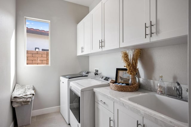 washroom featuring cabinets, sink, washer and clothes dryer, and light tile patterned floors