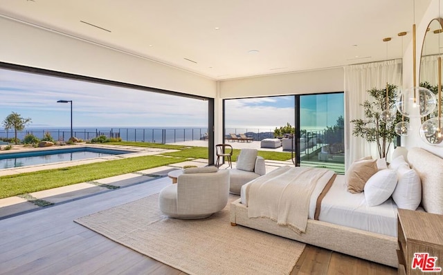 bedroom featuring a water view, access to exterior, and hardwood / wood-style floors