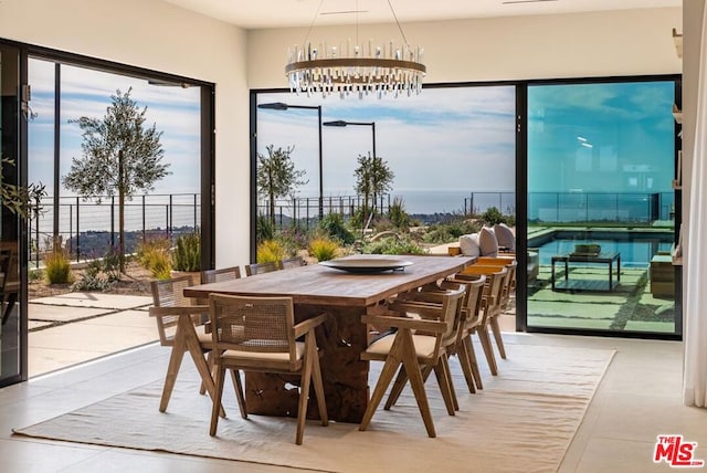 sunroom / solarium featuring a notable chandelier and a water view