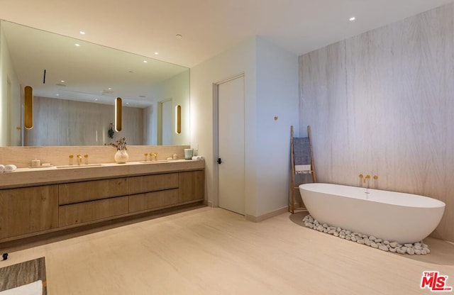 bathroom with a tub, hardwood / wood-style flooring, and vanity