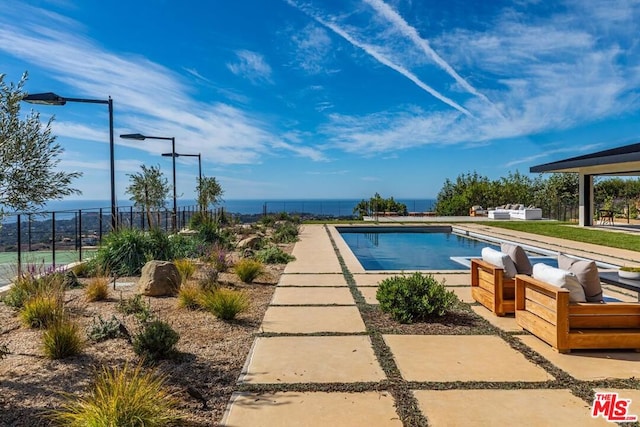 view of swimming pool featuring a water view and a patio area