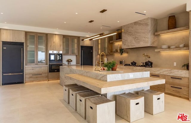 kitchen featuring a large island, stainless steel appliances, a kitchen breakfast bar, hanging light fixtures, and sink