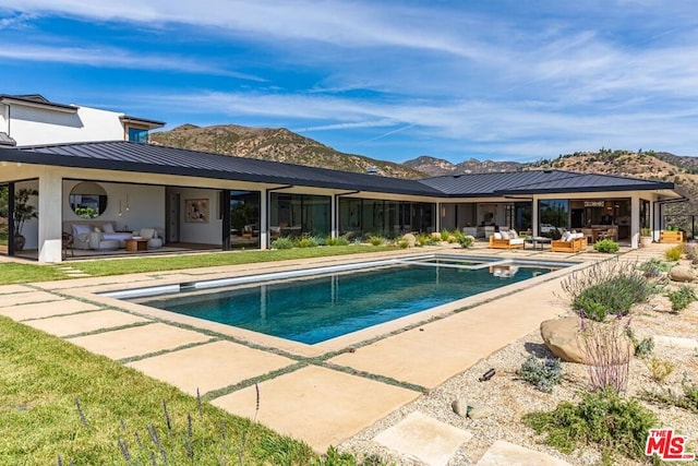 view of swimming pool with a mountain view, a patio area, and outdoor lounge area