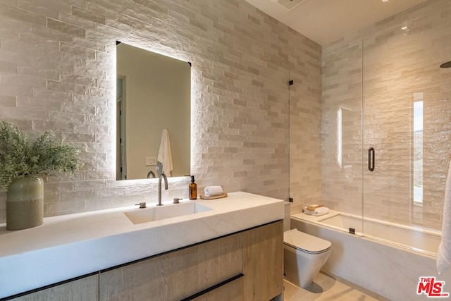 full bathroom with toilet, vanity, and shower / bath combination with glass door