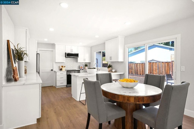 dining area featuring a healthy amount of sunlight and light hardwood / wood-style flooring