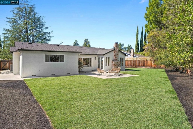 back of house with a lawn and a patio area