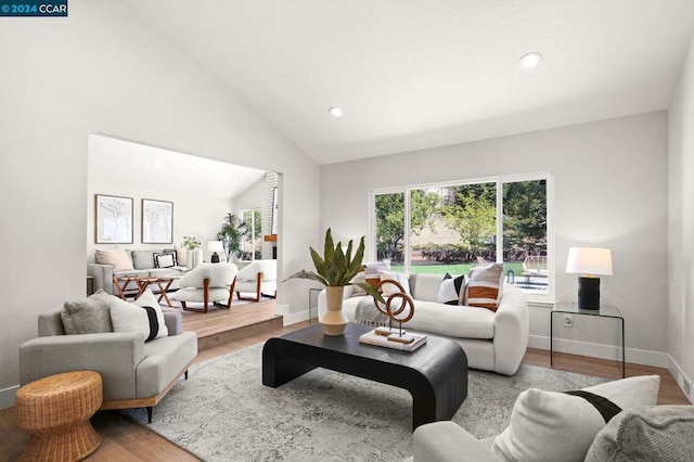 living room with light wood-type flooring and high vaulted ceiling