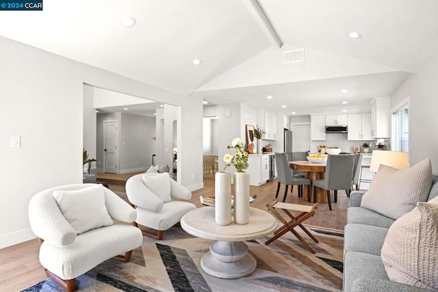 living room with lofted ceiling with beams and light hardwood / wood-style floors