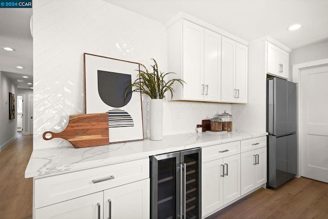 kitchen with white cabinets, stainless steel fridge, beverage cooler, and light stone counters