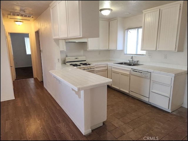 kitchen featuring white cabinetry, kitchen peninsula, tile counters, white appliances, and sink