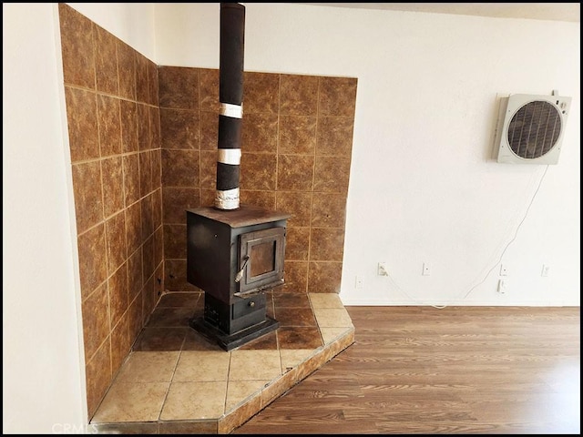 interior details featuring a wood stove, wood-type flooring, and ac unit