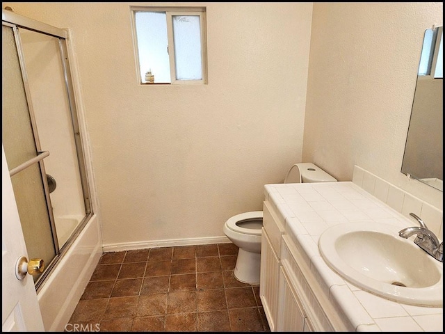 full bathroom with toilet, bath / shower combo with glass door, and vanity