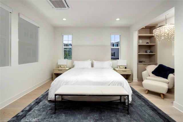 bedroom with hardwood / wood-style floors and a notable chandelier