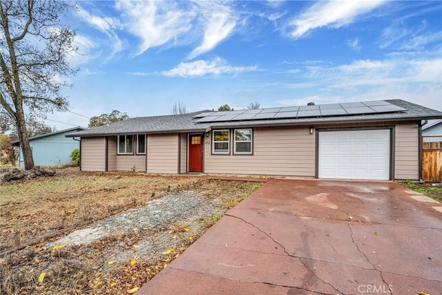 ranch-style home featuring solar panels and a garage