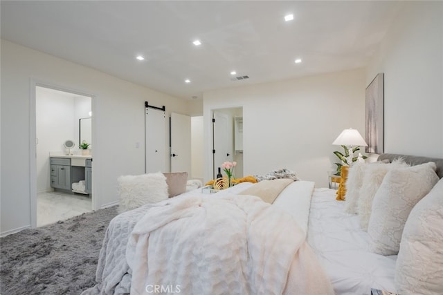 bedroom with ensuite bath and a barn door