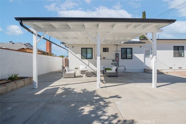 back of property with outdoor lounge area, a patio area, and a carport