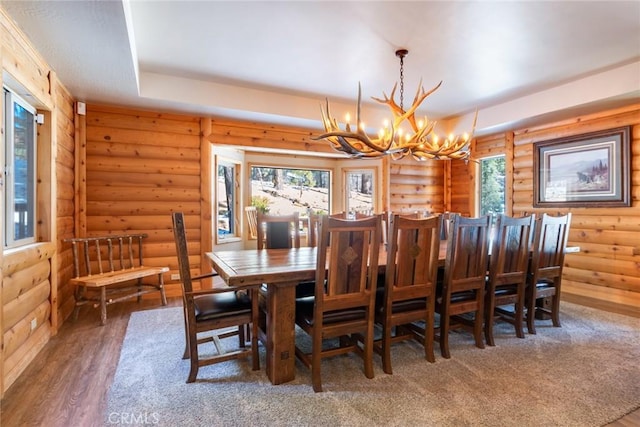 dining space with dark wood finished floors and an inviting chandelier