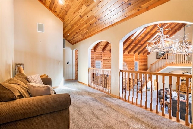 living area with wood ceiling, high vaulted ceiling, carpet floors, and an inviting chandelier