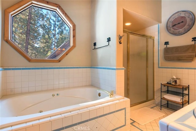 bathroom with independent shower and bath, tile patterned flooring, and tile walls