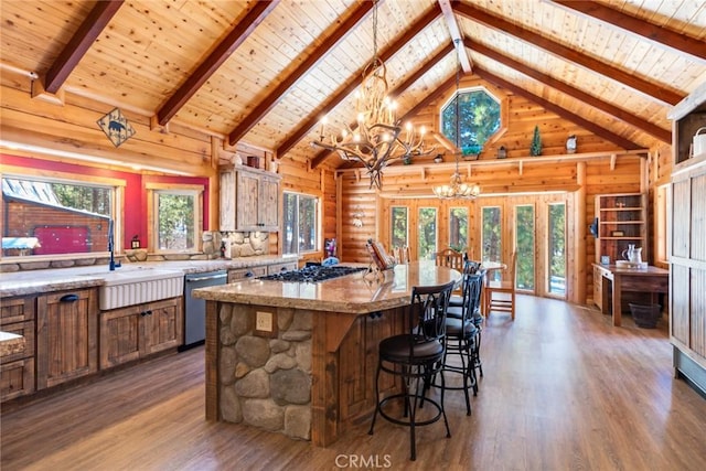 kitchen with pendant lighting, sink, an inviting chandelier, stainless steel appliances, and a kitchen island