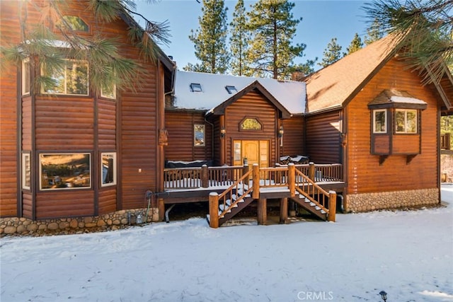 snow covered house featuring a deck