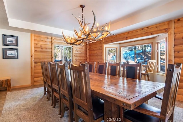 dining area with an inviting chandelier, wood-type flooring, and log walls