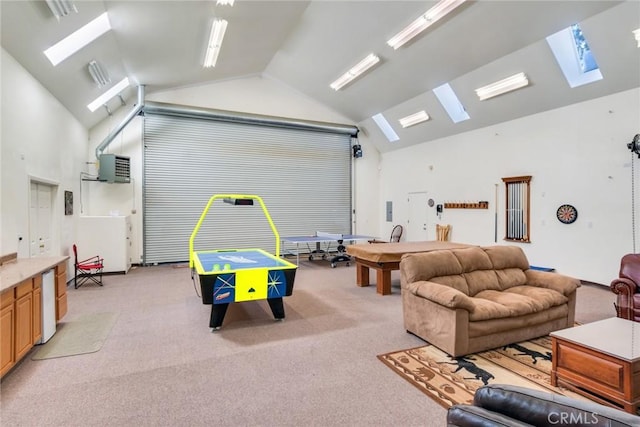 recreation room featuring a skylight, high vaulted ceiling, and light carpet