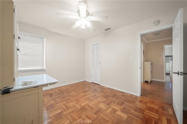 interior space featuring crown molding, ceiling fan, and light parquet flooring