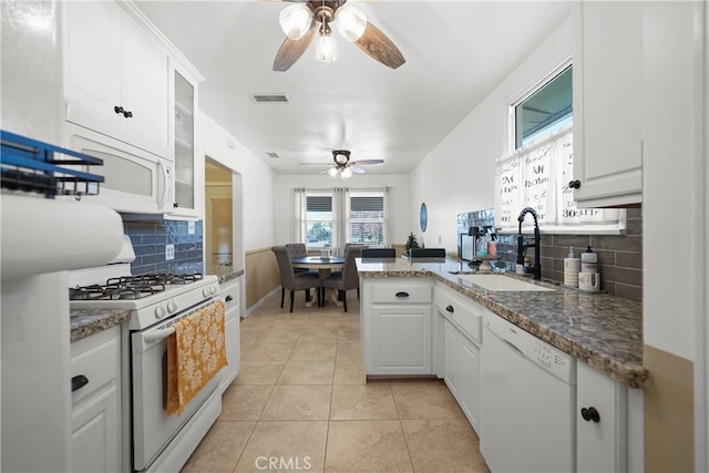 kitchen featuring sink, white cabinetry, light tile patterned floors, kitchen peninsula, and white appliances