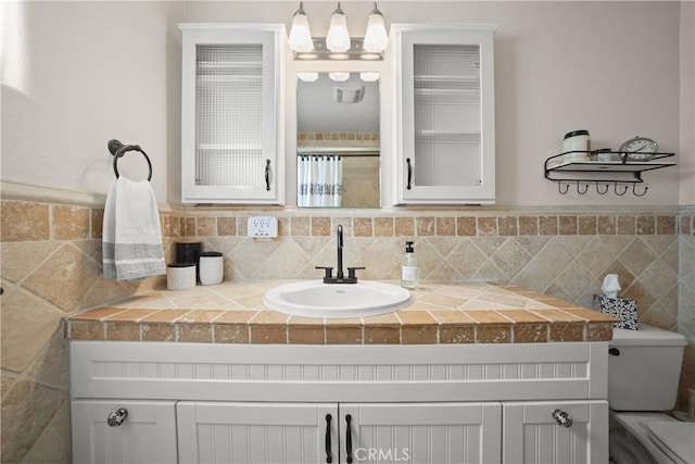 bathroom with vanity and tile walls