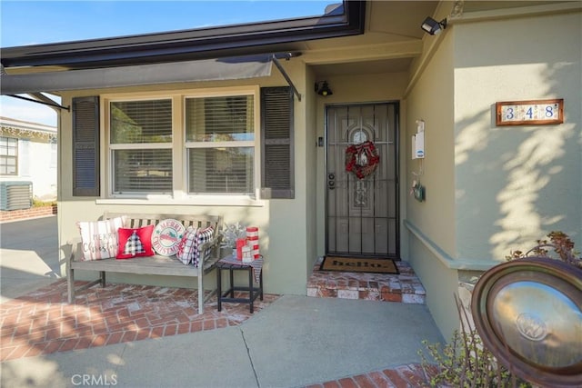 property entrance featuring a porch and central air condition unit