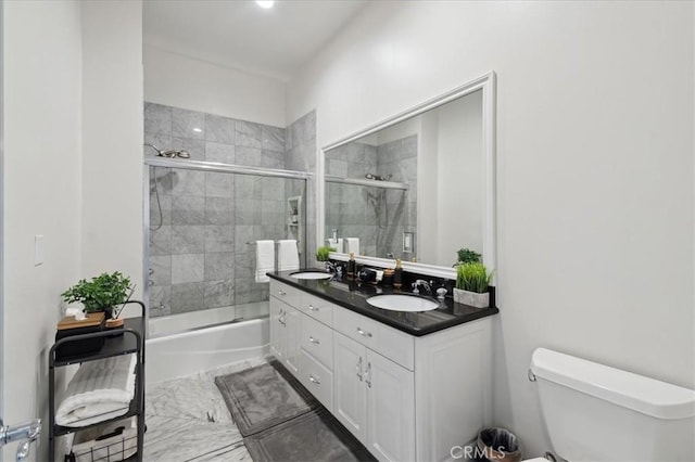 full bathroom featuring toilet, enclosed tub / shower combo, and vanity