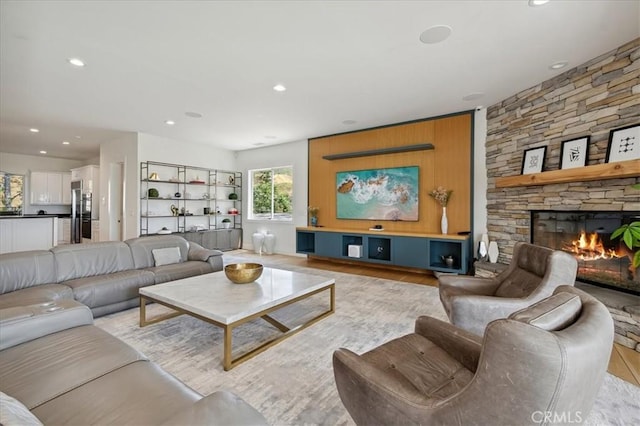 living room featuring light hardwood / wood-style flooring and a stone fireplace