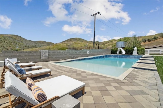 view of pool with a mountain view, a patio area, and a water slide