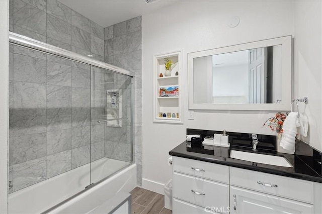 bathroom featuring combined bath / shower with glass door and vanity