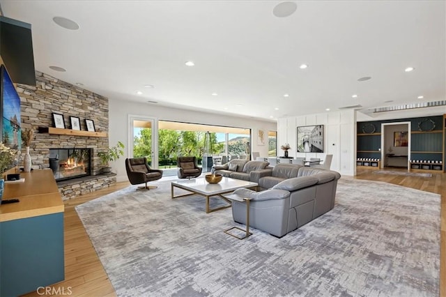 living room featuring hardwood / wood-style floors and a stone fireplace