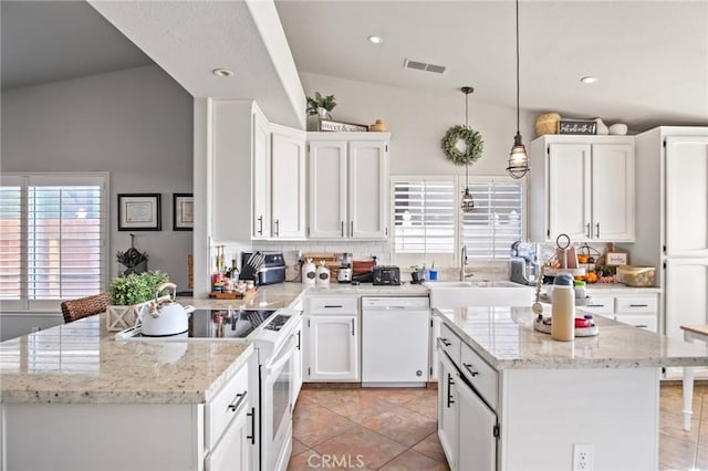 kitchen featuring white appliances, a center island, white cabinetry, hanging light fixtures, and light tile patterned flooring