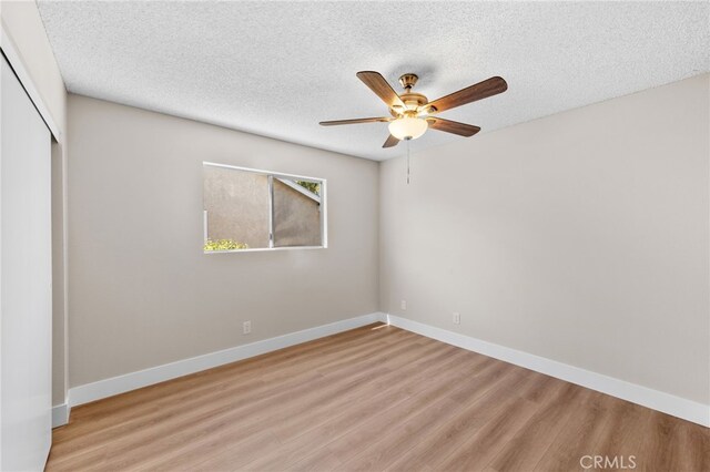 unfurnished room with a textured ceiling, ceiling fan, and light hardwood / wood-style flooring