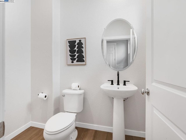 bathroom with hardwood / wood-style flooring and toilet