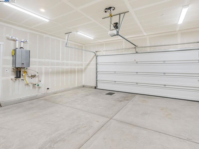 garage with water heater and a garage door opener