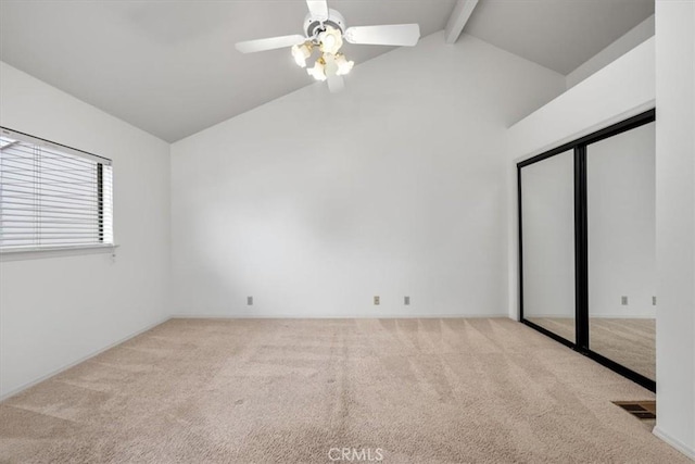 interior space with ceiling fan and vaulted ceiling with beams