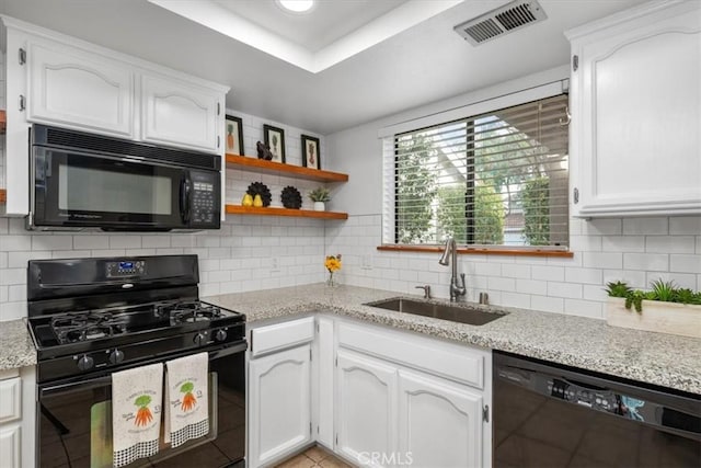 kitchen featuring sink, backsplash, white cabinets, and black appliances