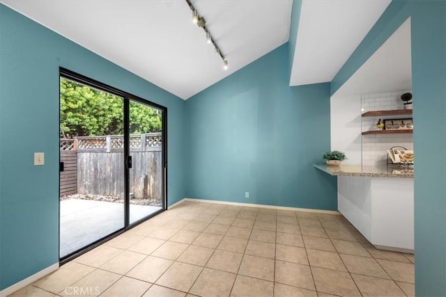 interior space featuring light tile patterned floors and lofted ceiling