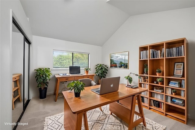 carpeted home office featuring vaulted ceiling