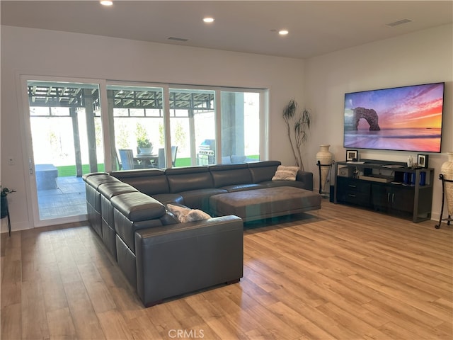 living area featuring light wood-type flooring, visible vents, and recessed lighting