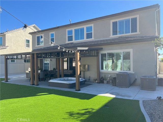 rear view of house with cooling unit, a hot tub, a yard, and a patio