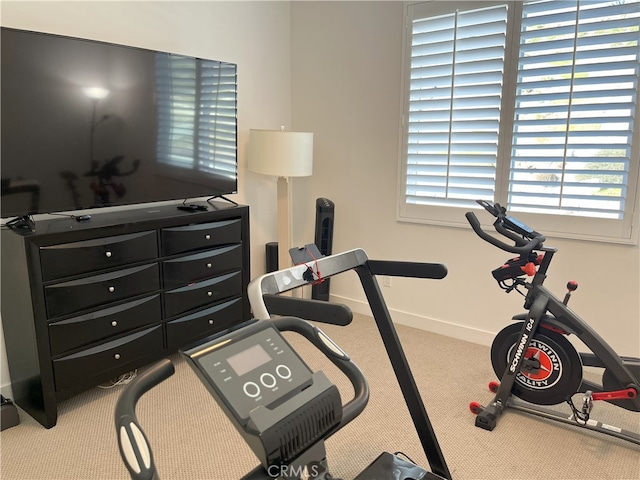 exercise area featuring carpet floors and baseboards