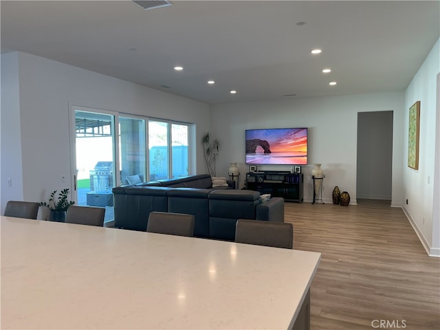 living area featuring recessed lighting, light wood-style flooring, and baseboards