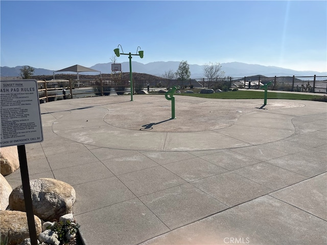 view of home's community with community basketball court, fence, and a mountain view