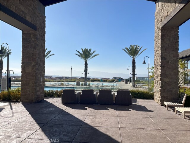 view of patio featuring a water and mountain view